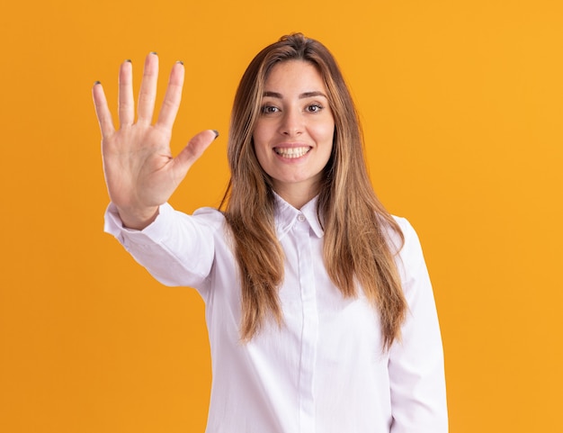 Souriante jeune fille assez caucasienne fait cinq gestes