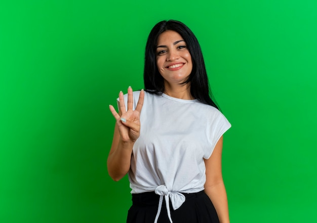 Souriante jeune fille caucasienne fait quatre gestes avec les doigts