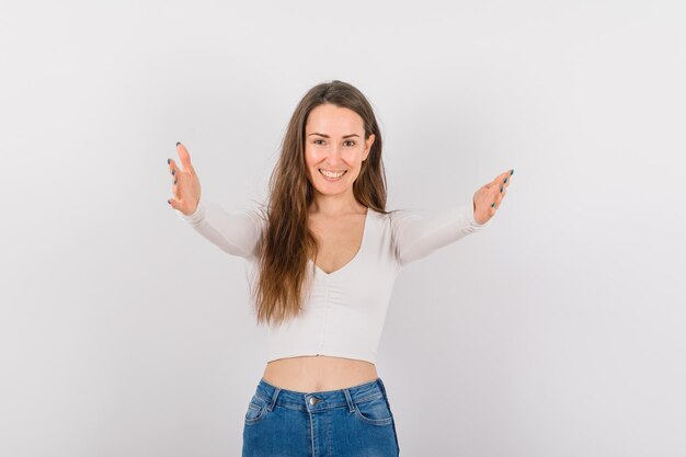 Souriante jeune fille tend les mains à la caméra sur fond blanc