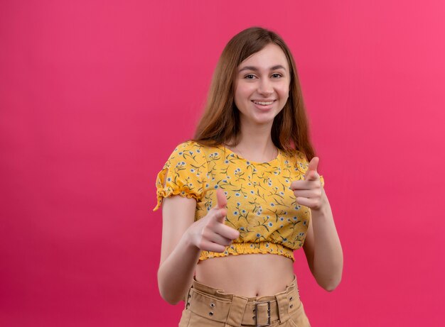 Souriante jeune fille vous faisant un geste sur un mur rose isolé avec espace de copie