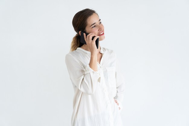 Souriante jeune jolie femme parlant sur smartphone. Concept de communication.