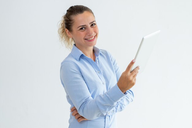 Souriante jolie jeune femme à l&#39;aide d&#39;une tablette