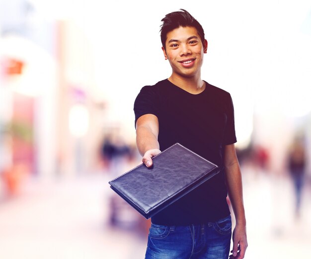 Sourire adolescent montrant un journal noir