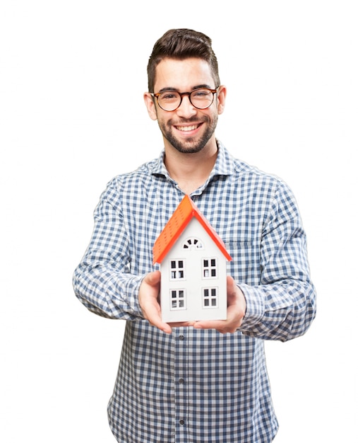 Sourire adulte montrant une maison en bois