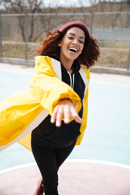 Sourire africaine jeune bouclée portant un manteau jaune