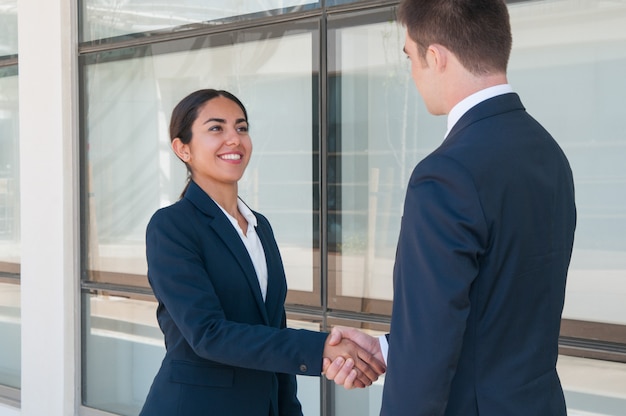 Sourire ambitieux femme d&#39;affaires disant au revoir à partenaire