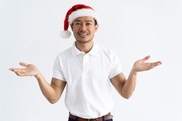 Sourire asiatique homme portant bonnet de Noel et levant les mains