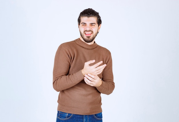 sourire beau modèle homme debout et en détournant les yeux.