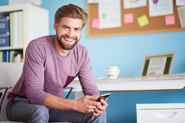 Sourire beaucoup en utilisant un téléphone portable