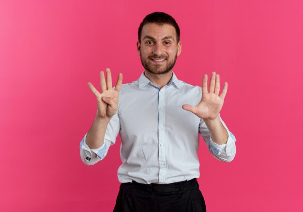 Sourire bel homme gestes neuf avec les mains isolées sur le mur rose