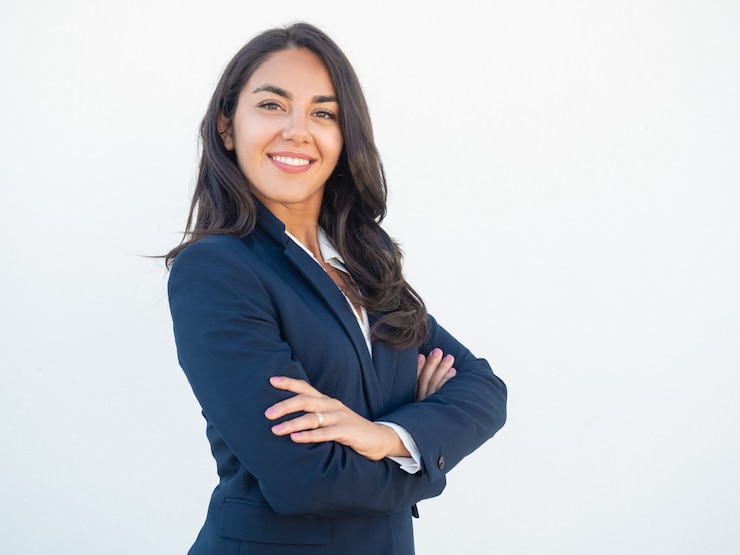 Photo gratuit sourire confiant femme d'affaires posant les bras croisés