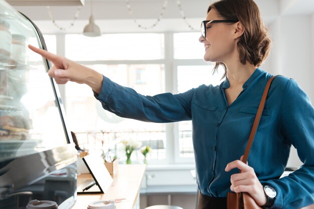 Sourire, confiant, femme, debout, vitrine, cafétéria