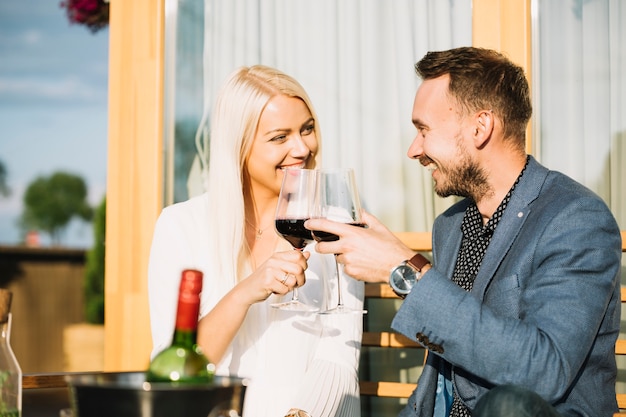 Sourire couple assis dans le restaurant griller le vin rouge