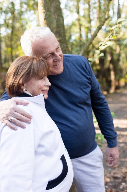 Sourire couple de personnes âgées posant dans le parc