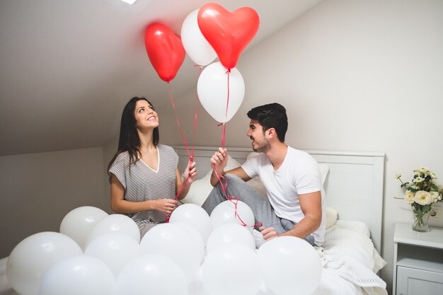 Sourire, couple, tenue ballons rouges et blancs