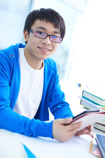 Sourire étudiant avec sa tablette numérique