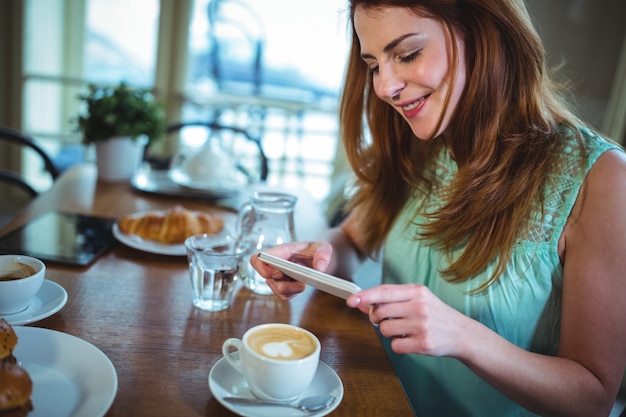 Sourire, femme cliquant photo de café depuis un téléphone mobile