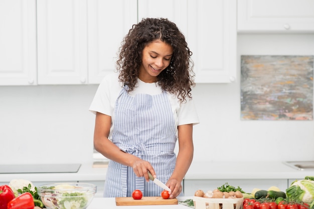 Sourire femme couper des tomates