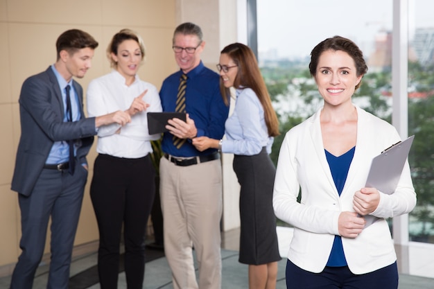 Sourire Femme exécutif debout devant l&#39;équipe