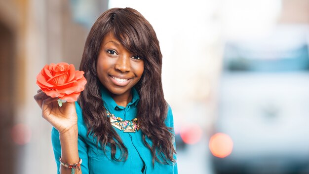 Sourire femme avec une fleur rouge
