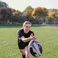 Photo gratuite sourire femme lancer un ballon de rugby