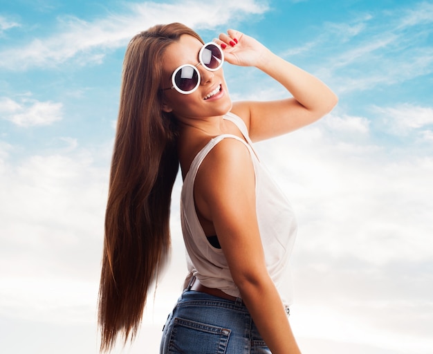 Sourire, femme, lunettes de soleil contre le ciel bleu