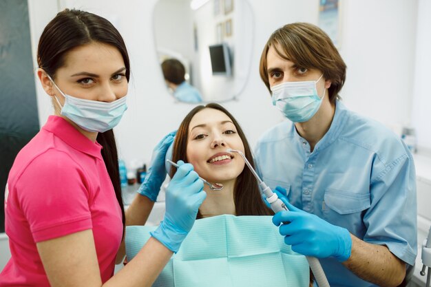 Sourire femme posant avec les dentistes