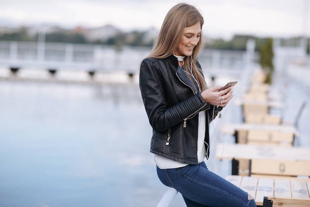 Sourire, femme regardant son téléphone intelligent