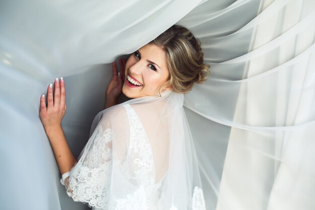 Sourire femme avec des rideaux blancs