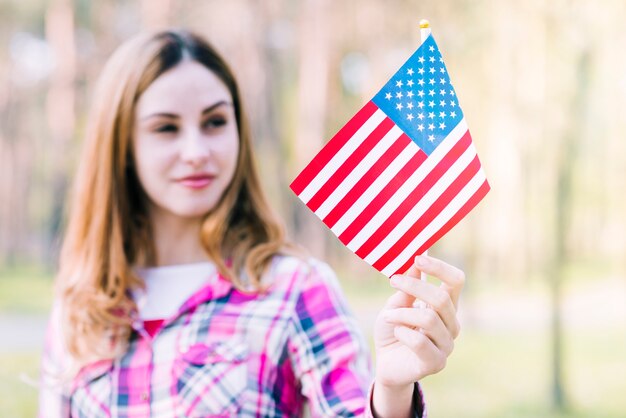 Sourire femme tenant le drapeau américain