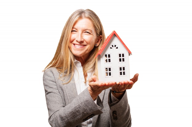 Sourire femme tenant une maison de jouets