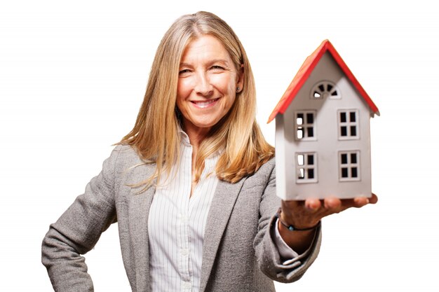 Sourire femme tenant une maison de jouets