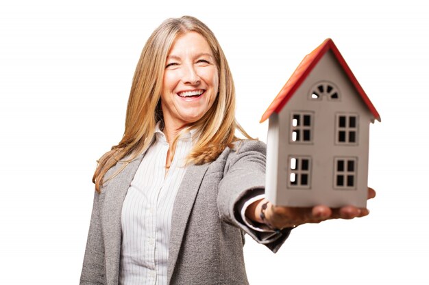 Sourire femme tenant une maison de jouets