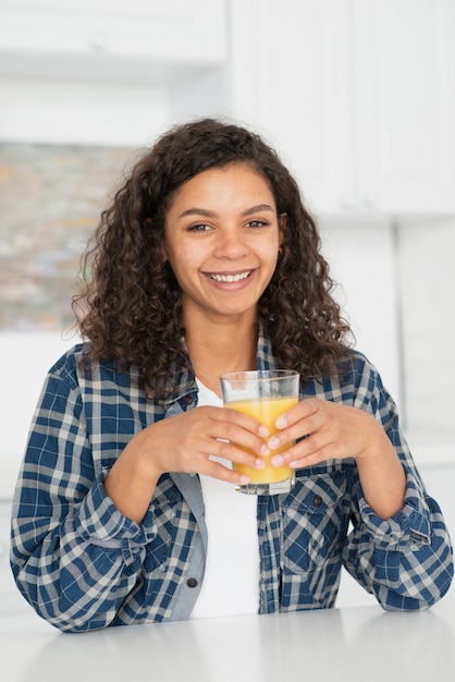 Photo gratuite sourire femme tenant un verre de jus d'orange