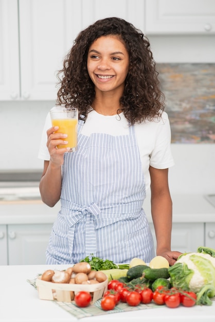 Sourire femme tenant un verre de jus