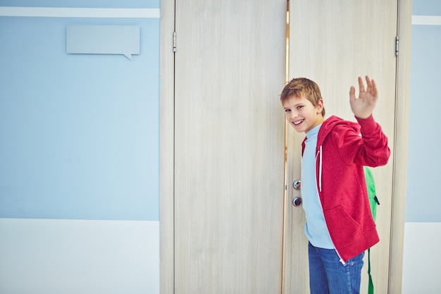 Sourire garçon disant au revoir