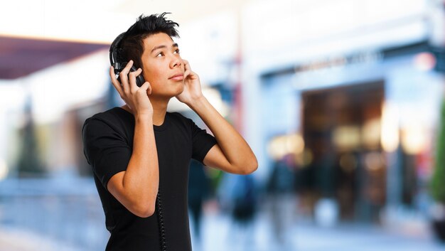 Sourire garçon écouter de la musique et levant les yeux