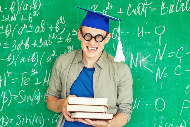 Photo gratuite sourire garçon avec des livres sur ses mains