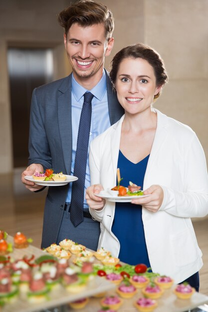 Sourire gens d&#39;affaires avec Snacks dans Buffet