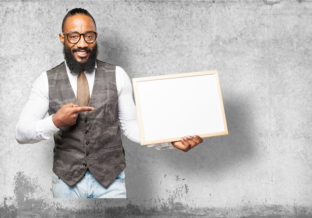 Sourire homme avec pointage cravate à un tableau blanc