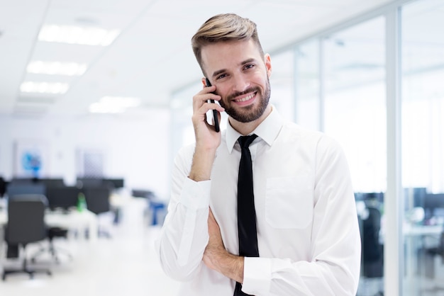 Sourire homme qui parle sur son smartphone