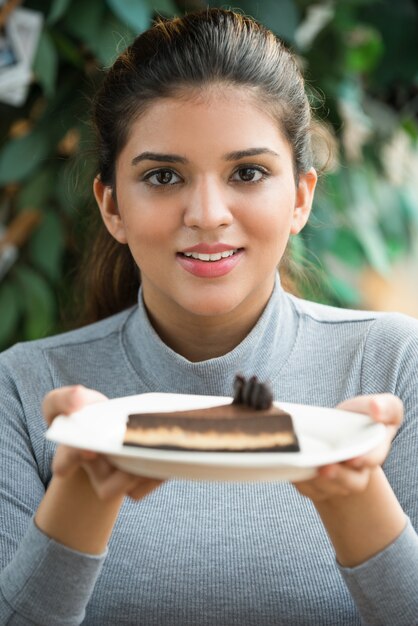 Sourire jeune femme indienne aimant dessert