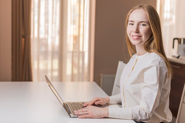 Sourire jeune femme avec un ordinateur portable