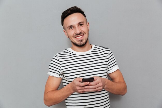 Sourire, jeune homme, bavarder, par, téléphone portable