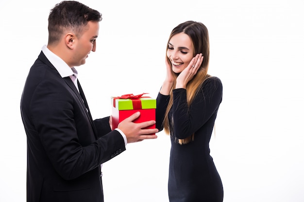 Sourire jeune homme et fille couple cadeau cadeau dans une boîte rouge sur blanc