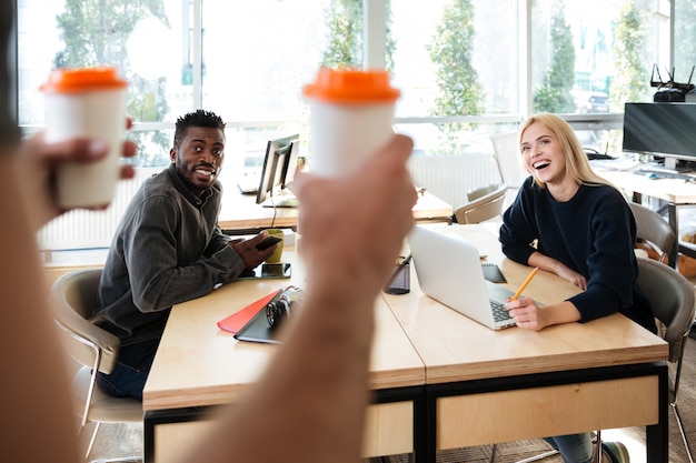 Photo gratuite sourire de jeunes collègues assis dans le coworking de bureau