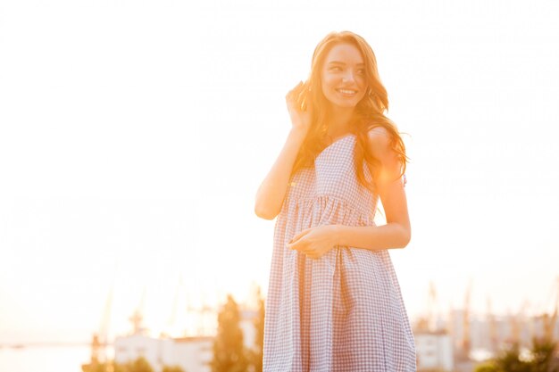 Sourire jolie femme au gingembre en robe écouter de la musique