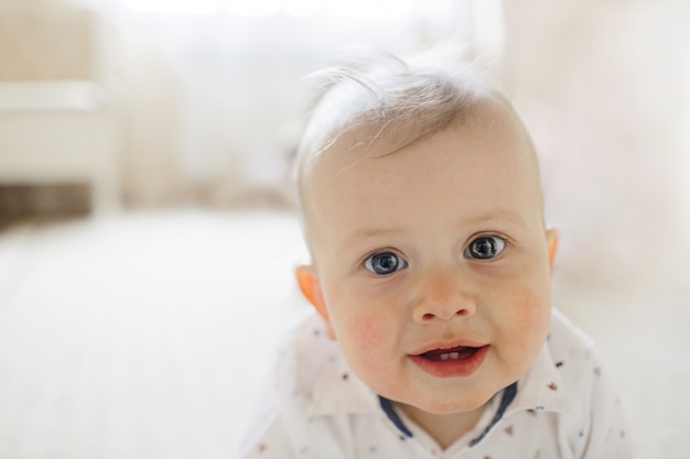 sourire mignon bébé aux yeux bleus