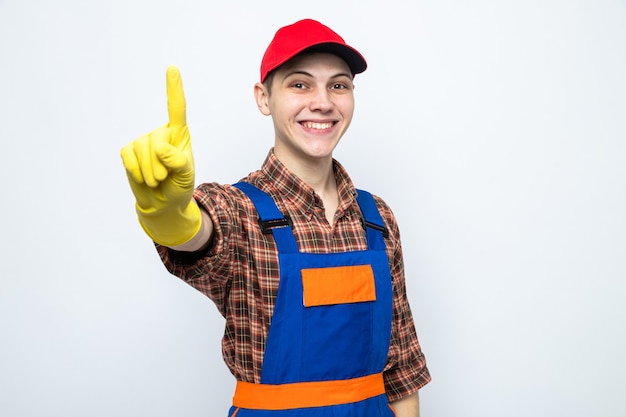 Sourire montrant un jeune homme de ménage portant un uniforme et une casquette avec des gants