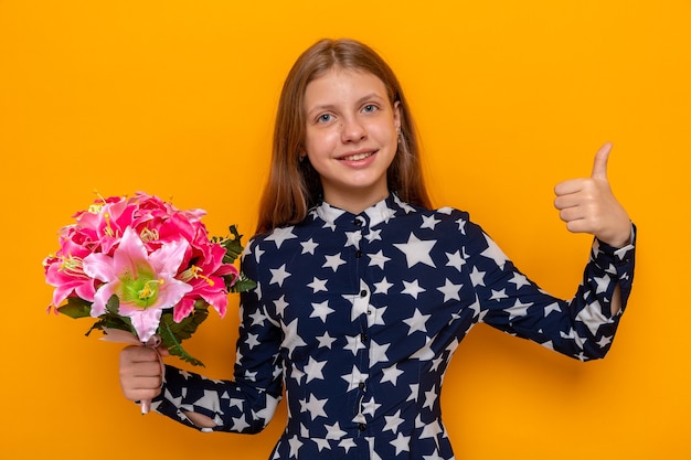 Sourire montrant le pouce vers le haut belle petite fille tenant le bouquet